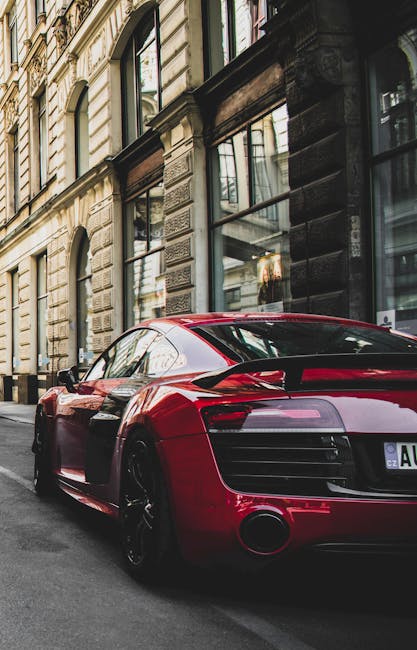 Sleek red sports car parked on a charming historic street in Prague, highlighting urban elegance and powerful design.